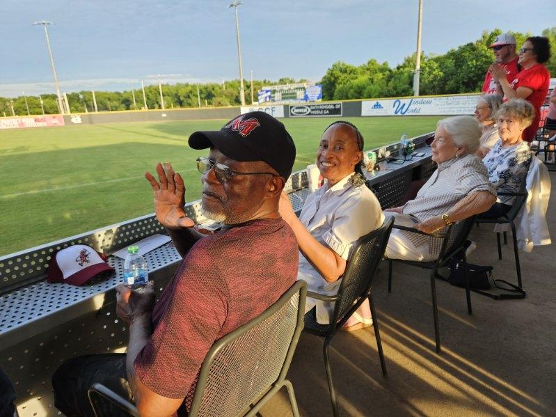 Guests seated along the rail overlooking the outfield before the Macon Bacon game.