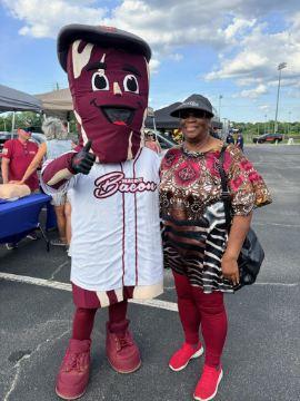 A guest poses with the Macon Bacon mascot outside the ballpark before the game.